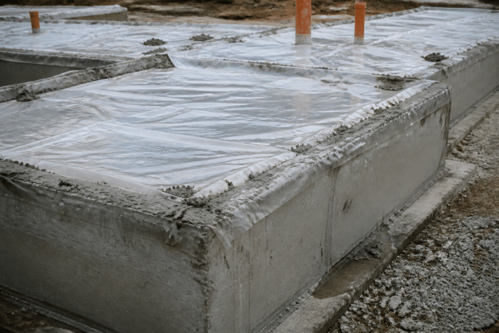 Couches de construction avec film plastique et béton gris