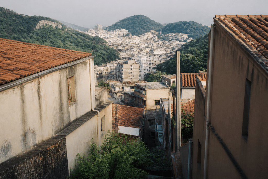 Maisons serrées entre collines boisées et zone urbaine dense