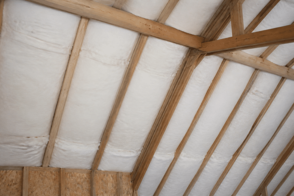 Rouleaux isolants blancs installes entre chevrons combles