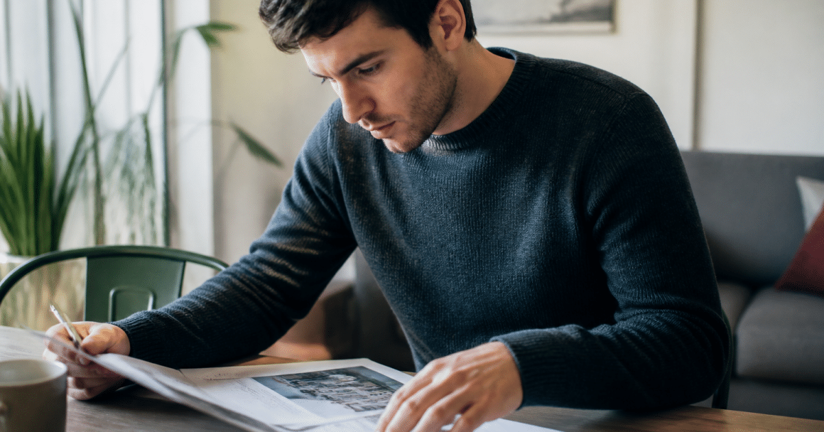 Locataire consultant document immobilier sur table avec stylo