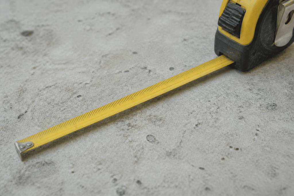 Ruban de mesure montrant centimetres et metres sur surface concrete