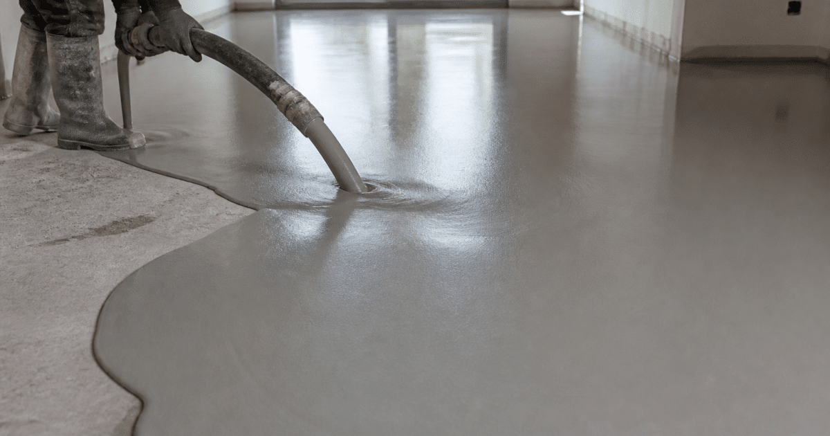 Mortier anhydrite gris versé uniformément sur surface plane de chantier