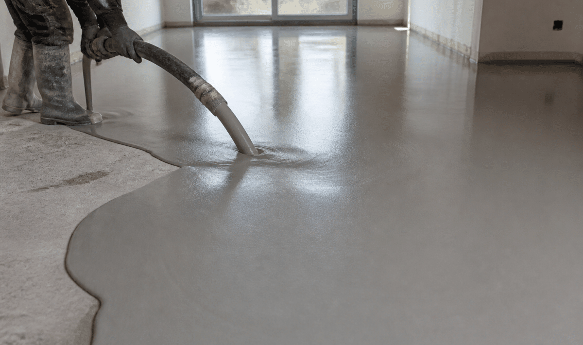 Mortier anhydrite gris versé uniformément sur surface plane de chantier