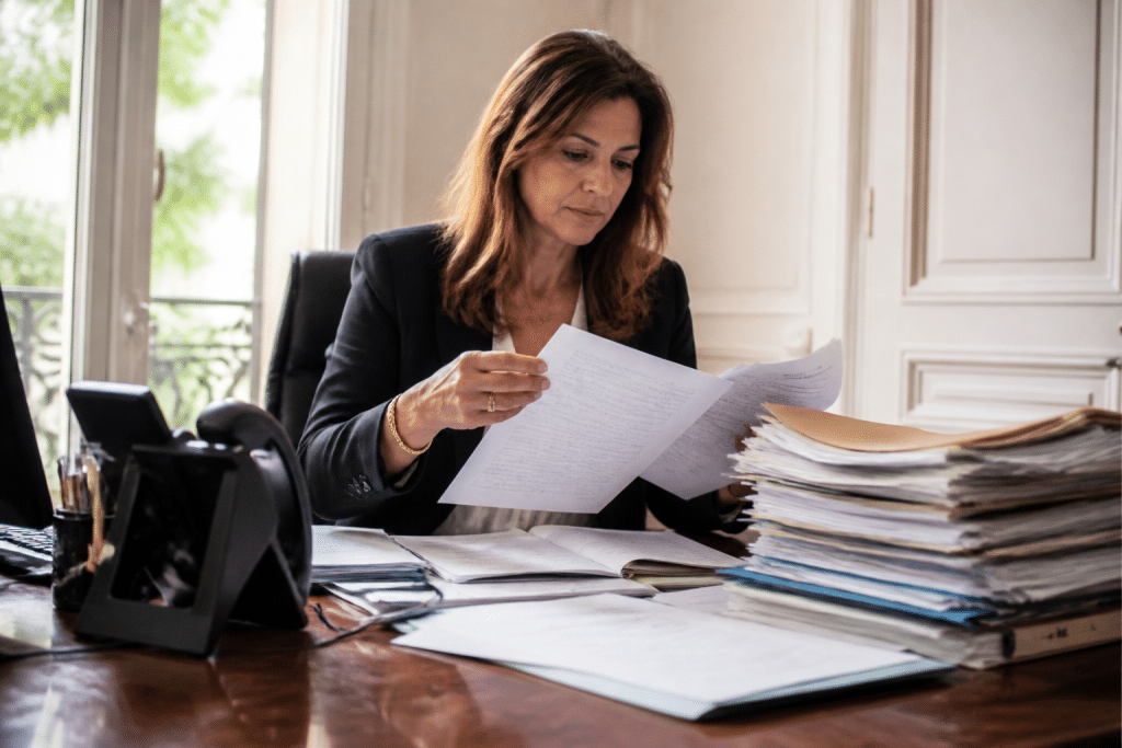 Notaire examinant documents immobiliers avec dossier administratif ouvert