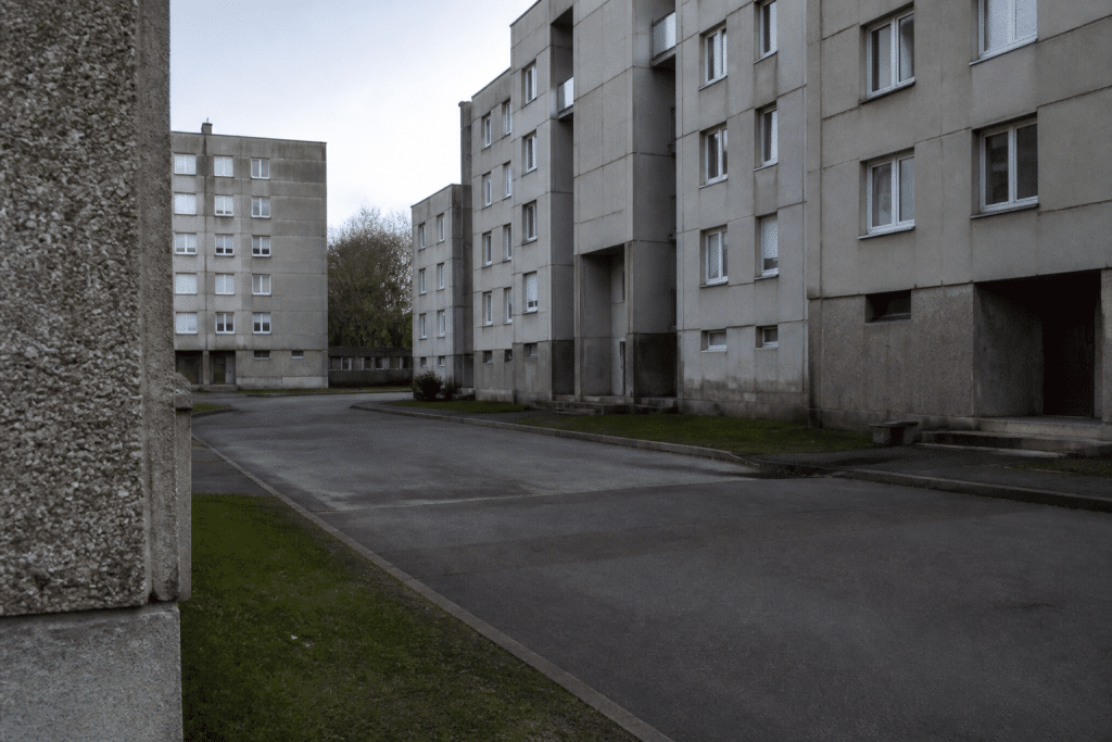 Quartier périphérique désert avec immeubles gris et rues vides
