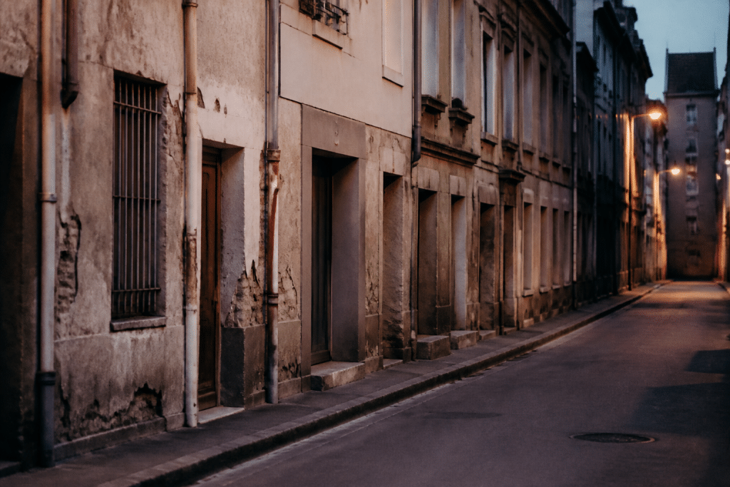 Immeubles ancien avec facades degradees et rue desertee le soir