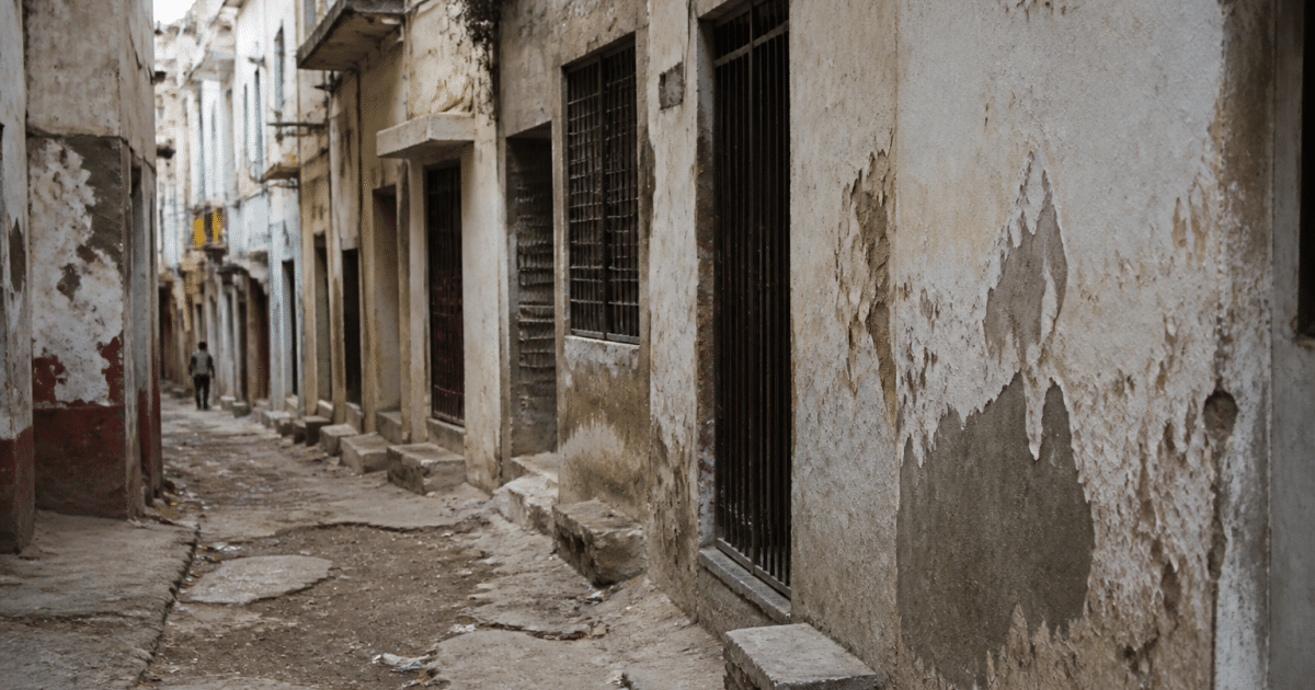 Rue degradee avec batiments delabres et facades usees