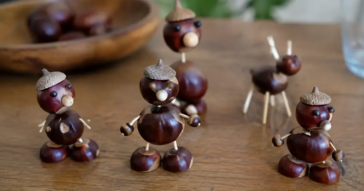 Figurines en chataignes posees sur table en bois