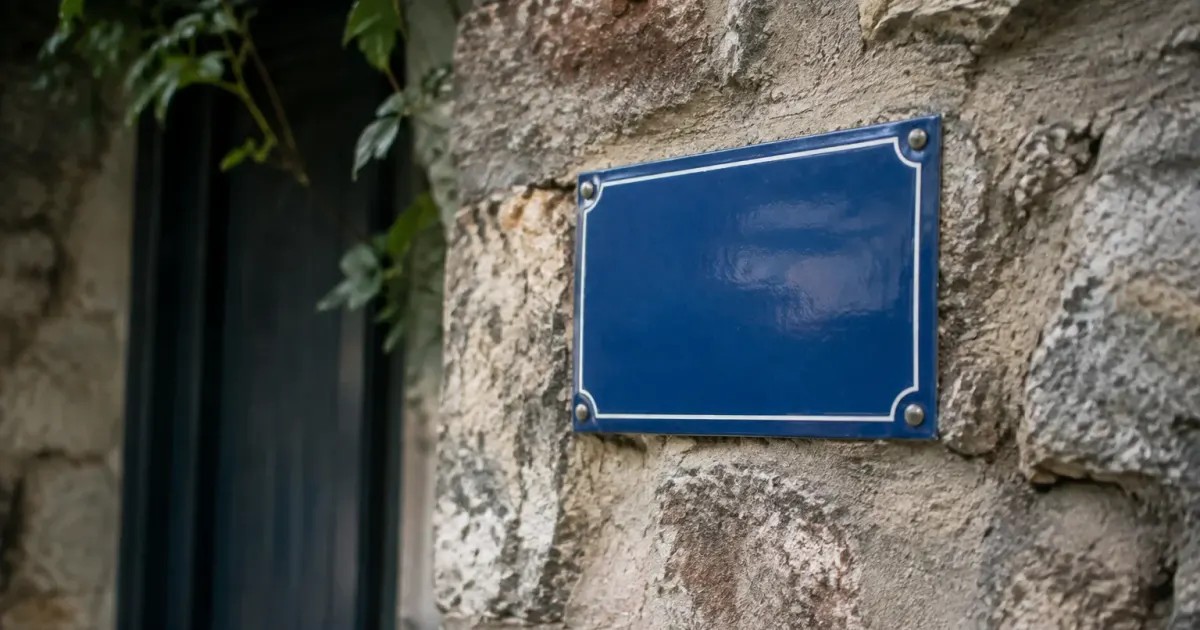 Plaque bleue fixee sur mur en pierre ancienne