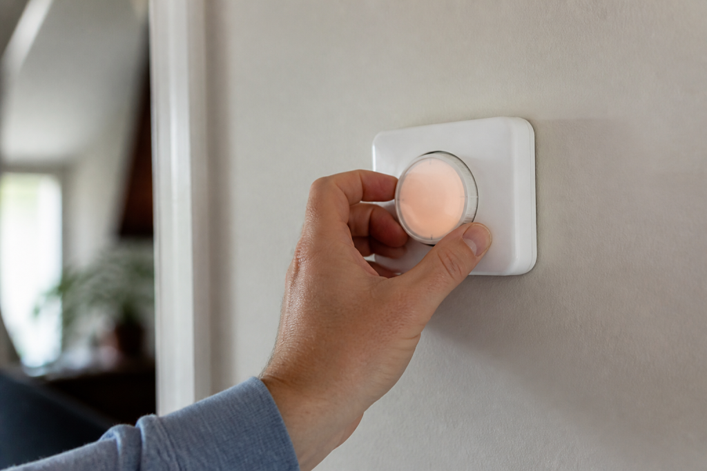 Main ajuste thermostat blanc affichant temperature